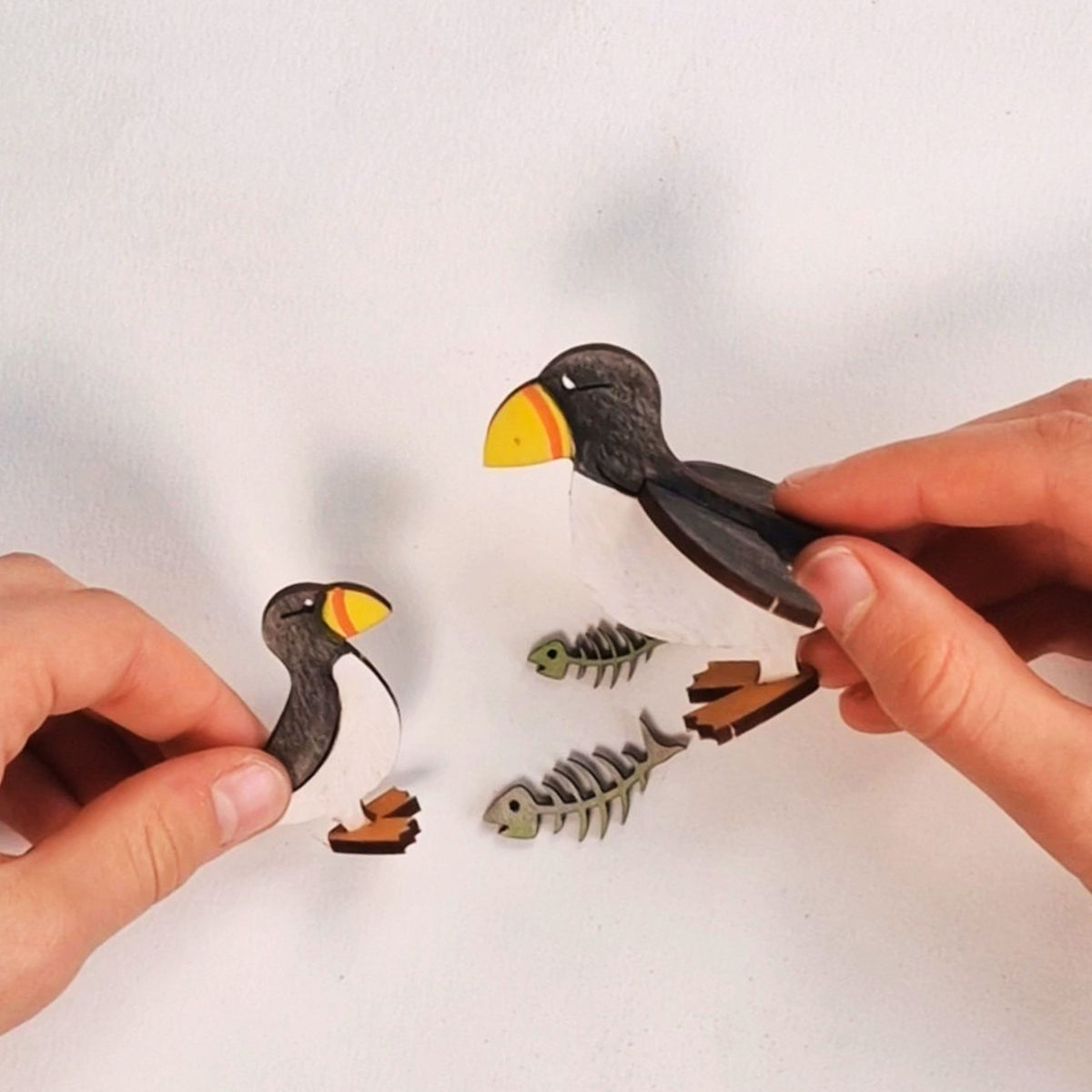 Popping out the pieces and clipping together a wooden puffin and puffling from the Puffin Wooden Craft Kit